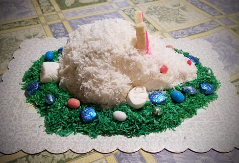 Red Velvet Cake covered with Cream Cheese Frosting Coconut, surrounded by Grass Coconut and Easter Candies