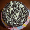 Double-Layer Chocolate Cake with Chocolate Frosting, Covered in Chocolate Chips, and Topped with Melted White Chocolate