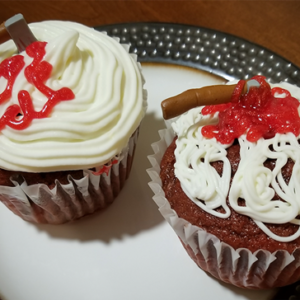 Red Velvet Cupcakes with cream cheese frosting and bloody hatchets