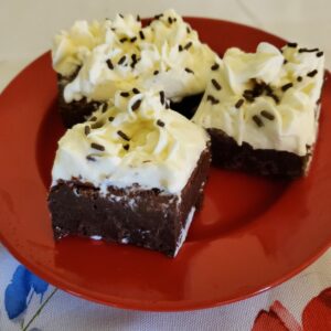 Chocolate fudge brownies with cream cheese frosting and topped with chocolate sprinkles